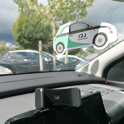 Intérieur d'une voiture avec un support pour téléphone et un sent bon 123 Pare-Brise