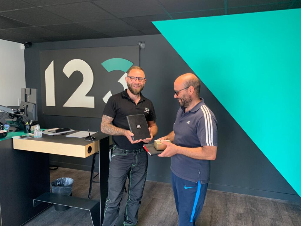 123PareBrise-Wattrelos-client-satisfait Remise d'une pochette 123 Pare-Brise à un client satisfait